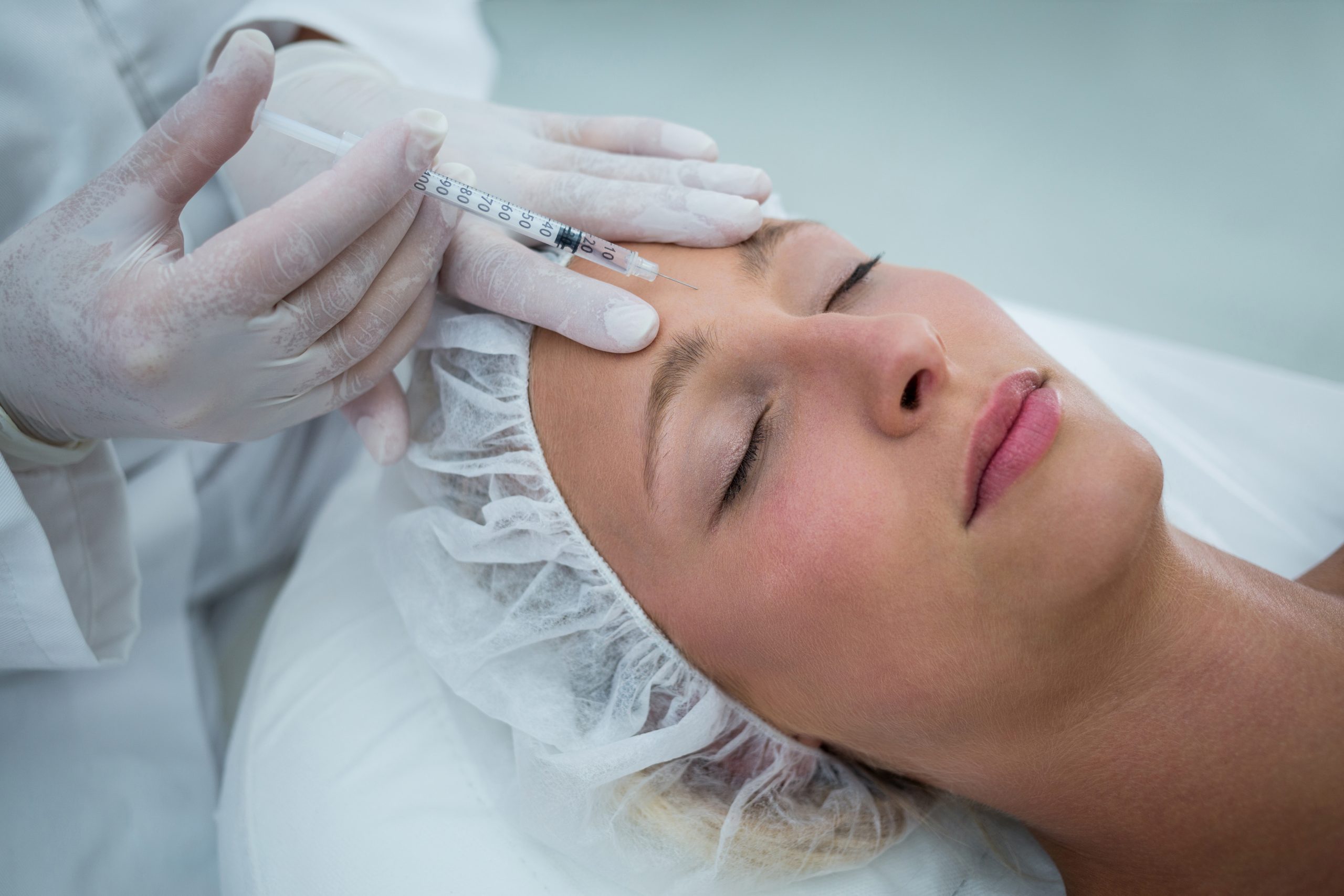 close up of female patient receiving a botox injection on forehead